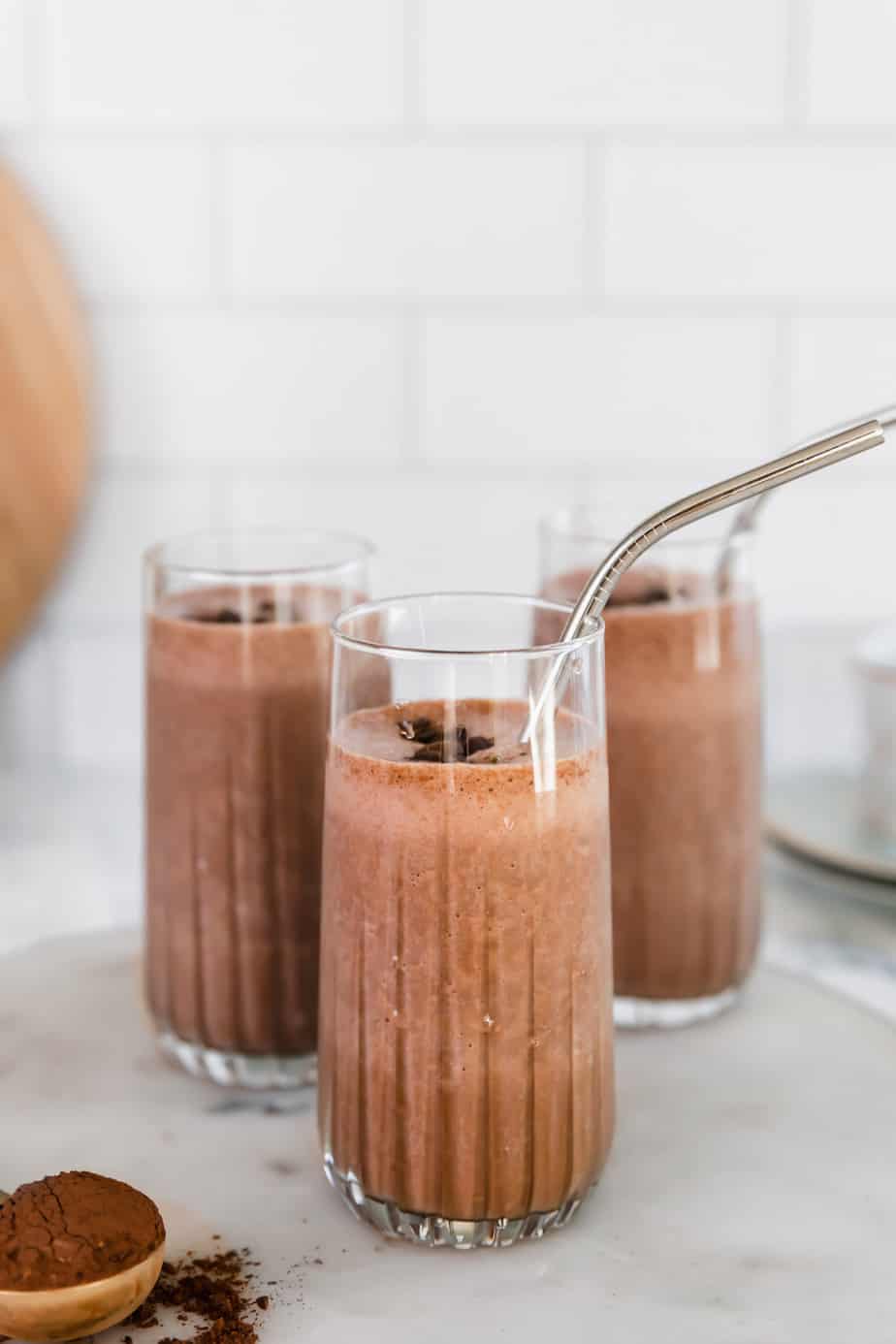 Three tall glasses filled with mocha smoothie and topped with a few coffee beans.