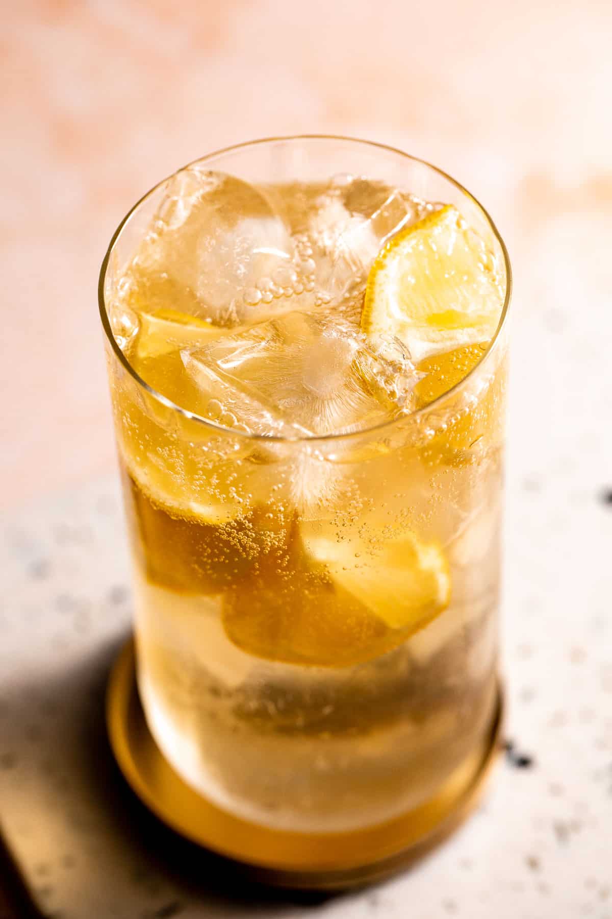 A glass of 7 and 7 sitting on a marble board,.