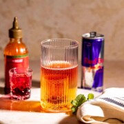 A Chuck Norris shot sitting on a marble tray next to a can of Red Bull.