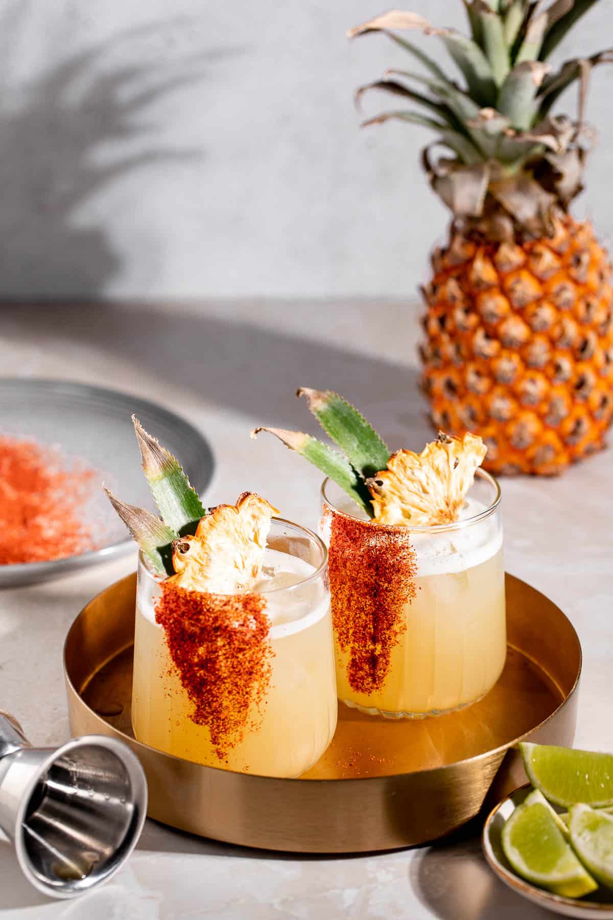 Two mezcalitas sitting on a gold serving tray.