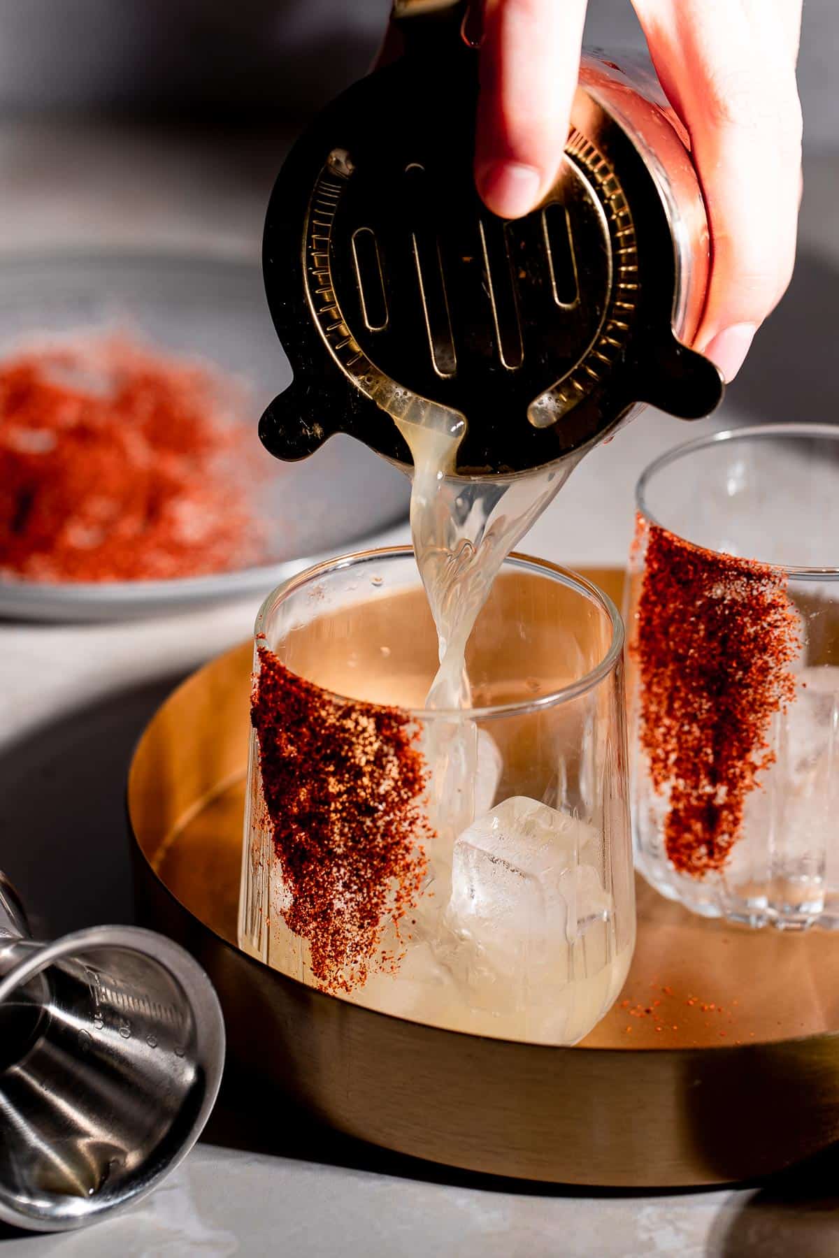 A mezcalita being poured into a serving glass from a cocktail shaker.