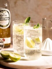 Two highball glasses of tequila and sprite sitting on a marble tray.