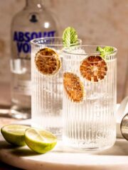 Two highball glasses filled with vodka and Sprite sitting on a marble tray.