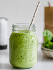 A spinach and pineapple smoothie served in a mason jar.
