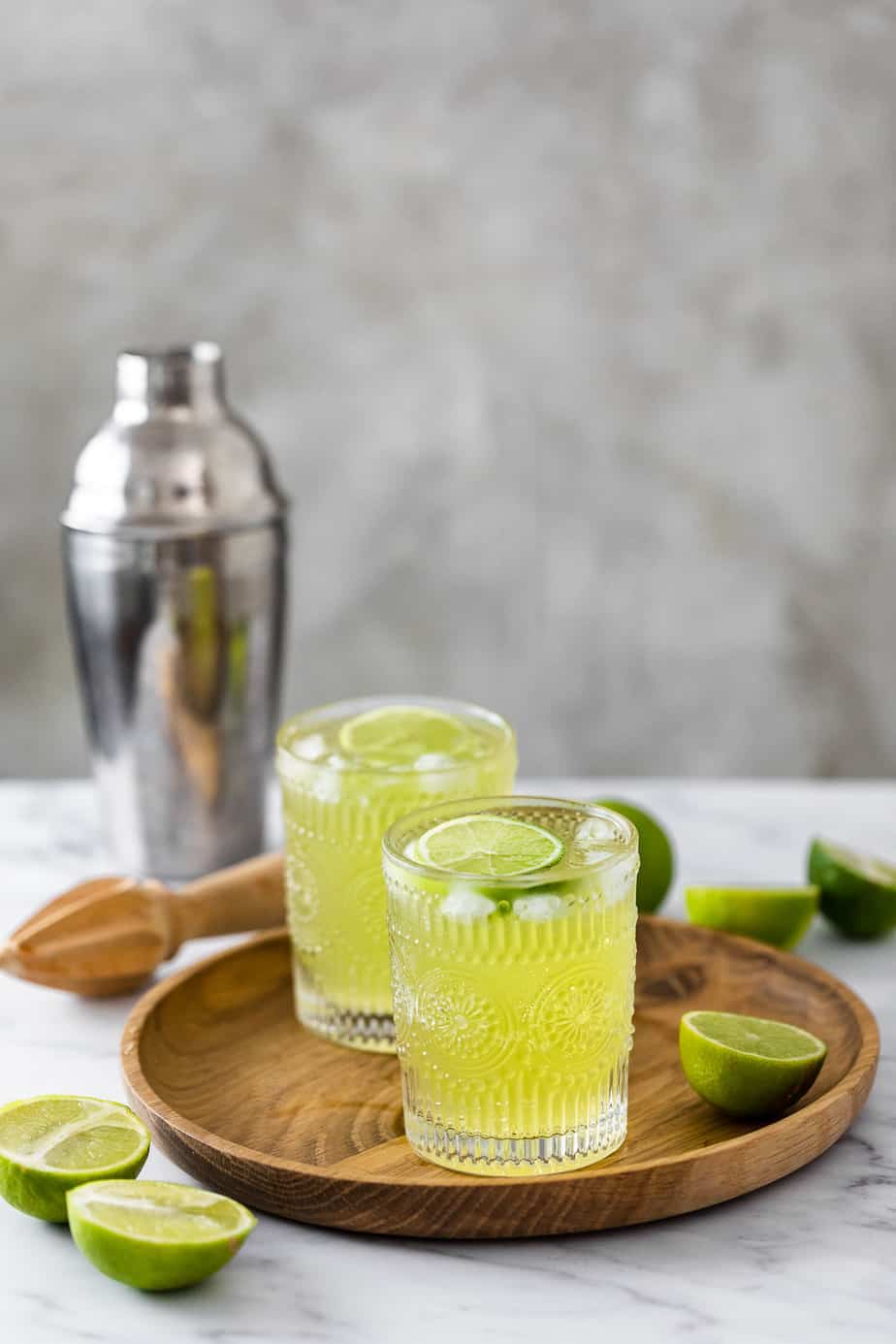 Two glasses filled with Midori Tokyo tea served on a wooden tray.