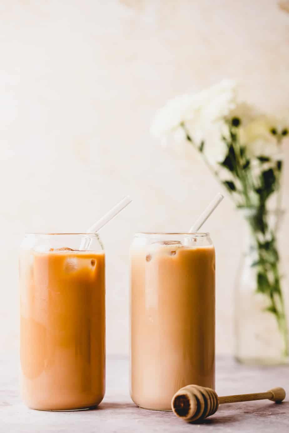 Two tall glasses filled with honey almond milk cold brew sitting on a counter.