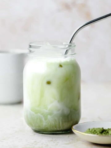 An iced vanilla matcha latte served in a mason jar.