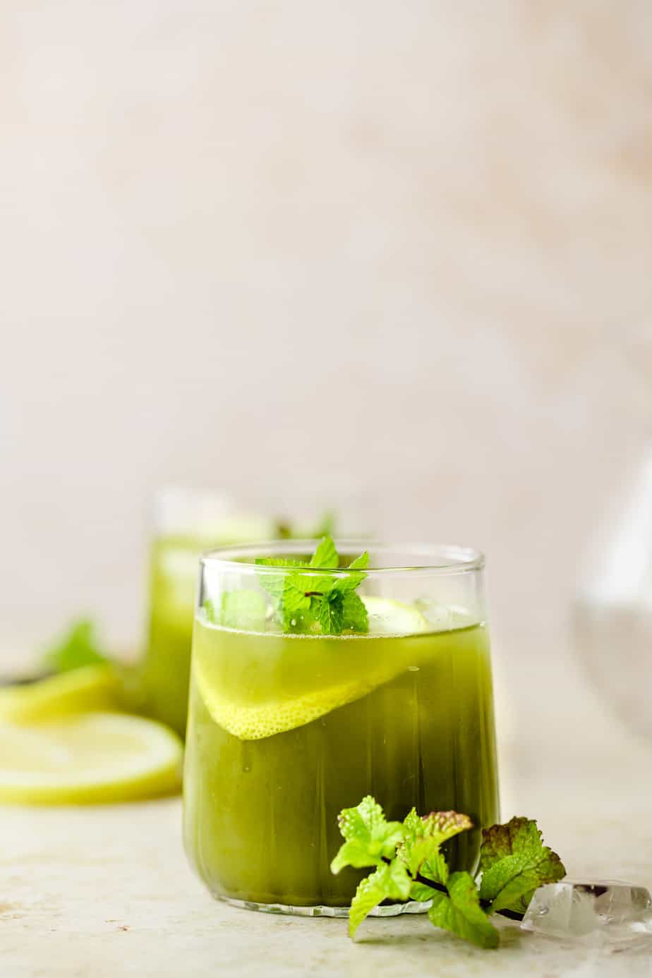 A glass of DIY Starbucks matcha lemonade with fresh mint and lemon.