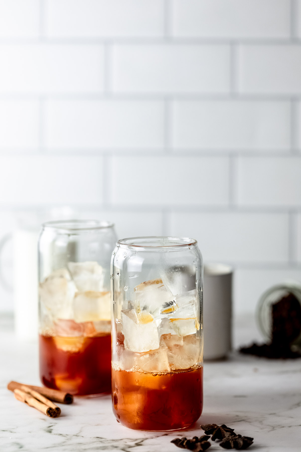 Two serving glasses filled with ice and chai coffee concentrate.