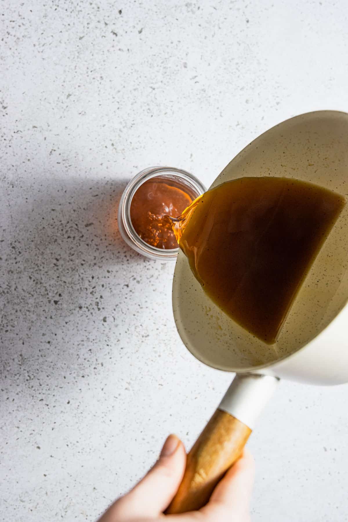 Honey simple syrup being poured into a jar.