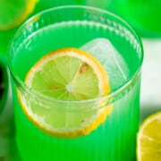 three midori sour cocktails garnished with lemon