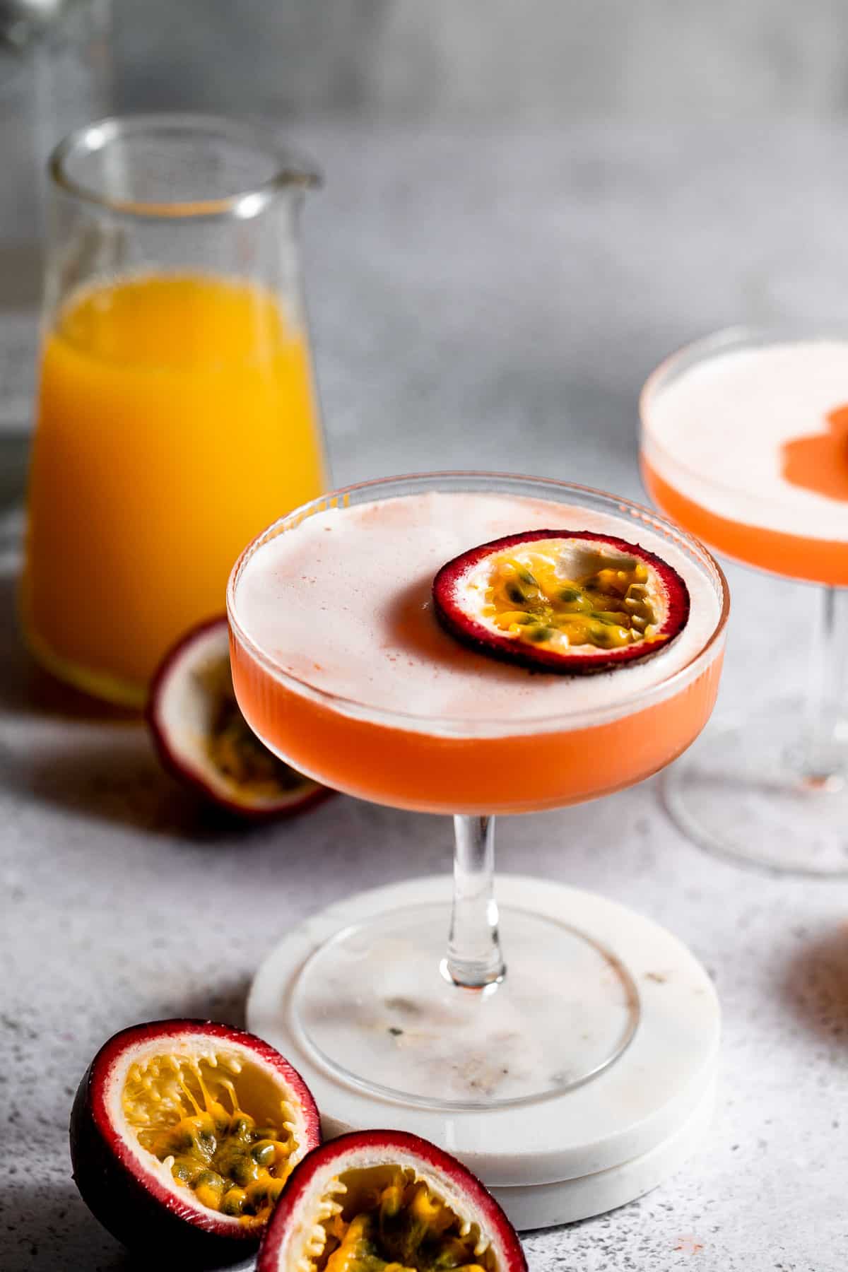 A pornstar martini in coupe glass topped with halved passion fruit.