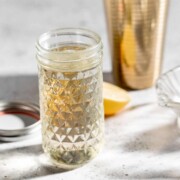 simple syrup in glass jar with gold cocktail shaker