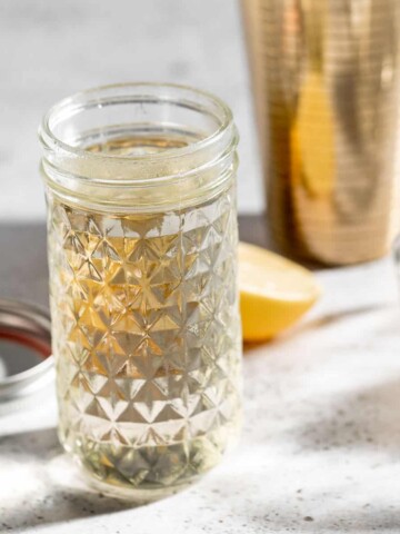 simple syrup in glass jar with gold cocktail shaker