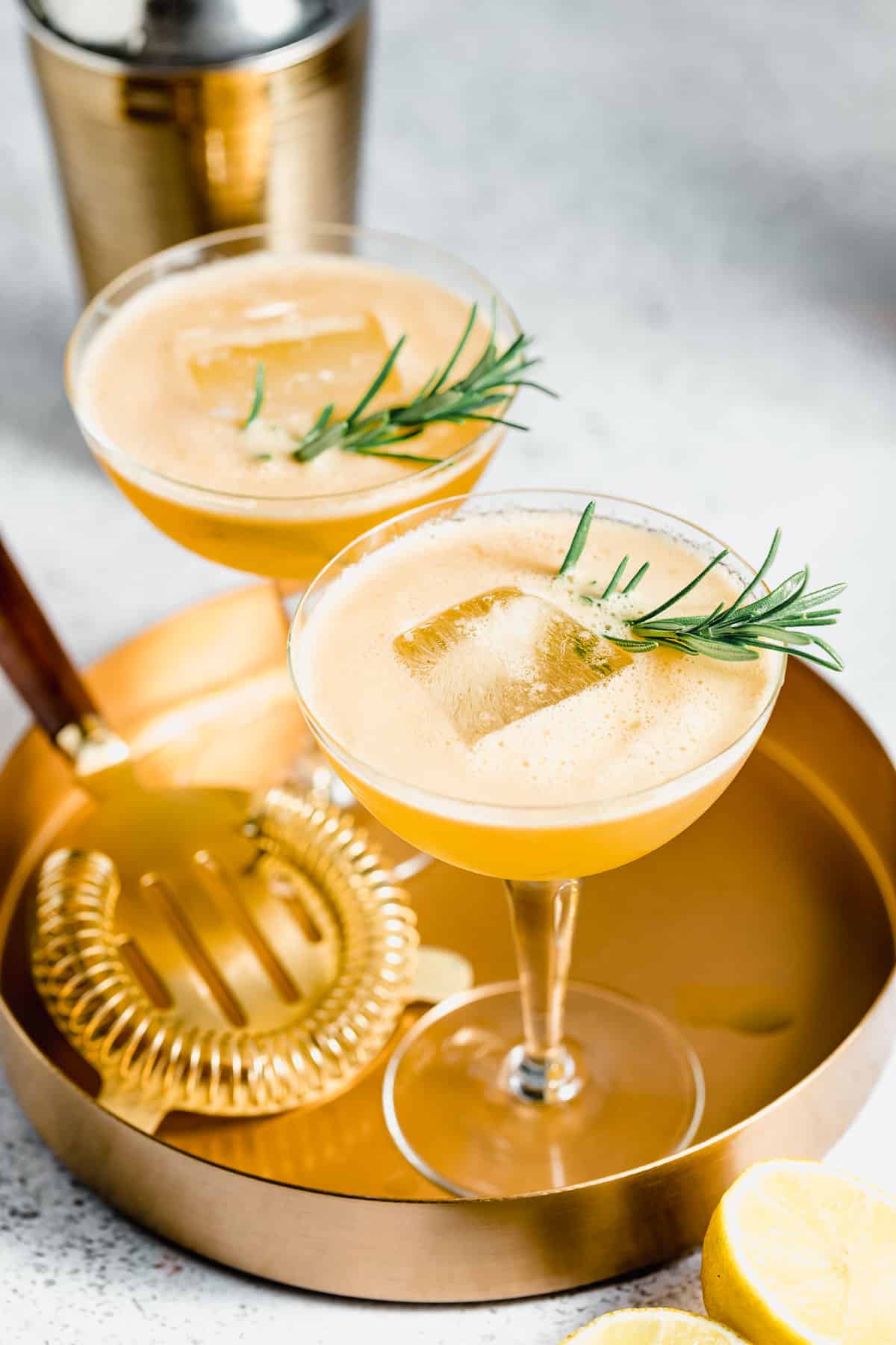 two glasses of bourbon smash sitting on a gold tray.