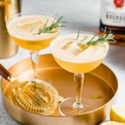 Two glasses of bourbon smash sitting on a gold serving tray.