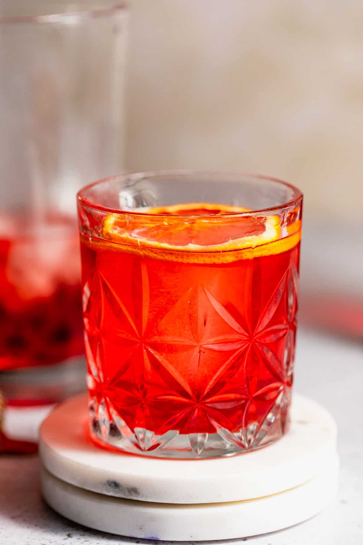 A mezcal negroni sitting on a marble coaster.
