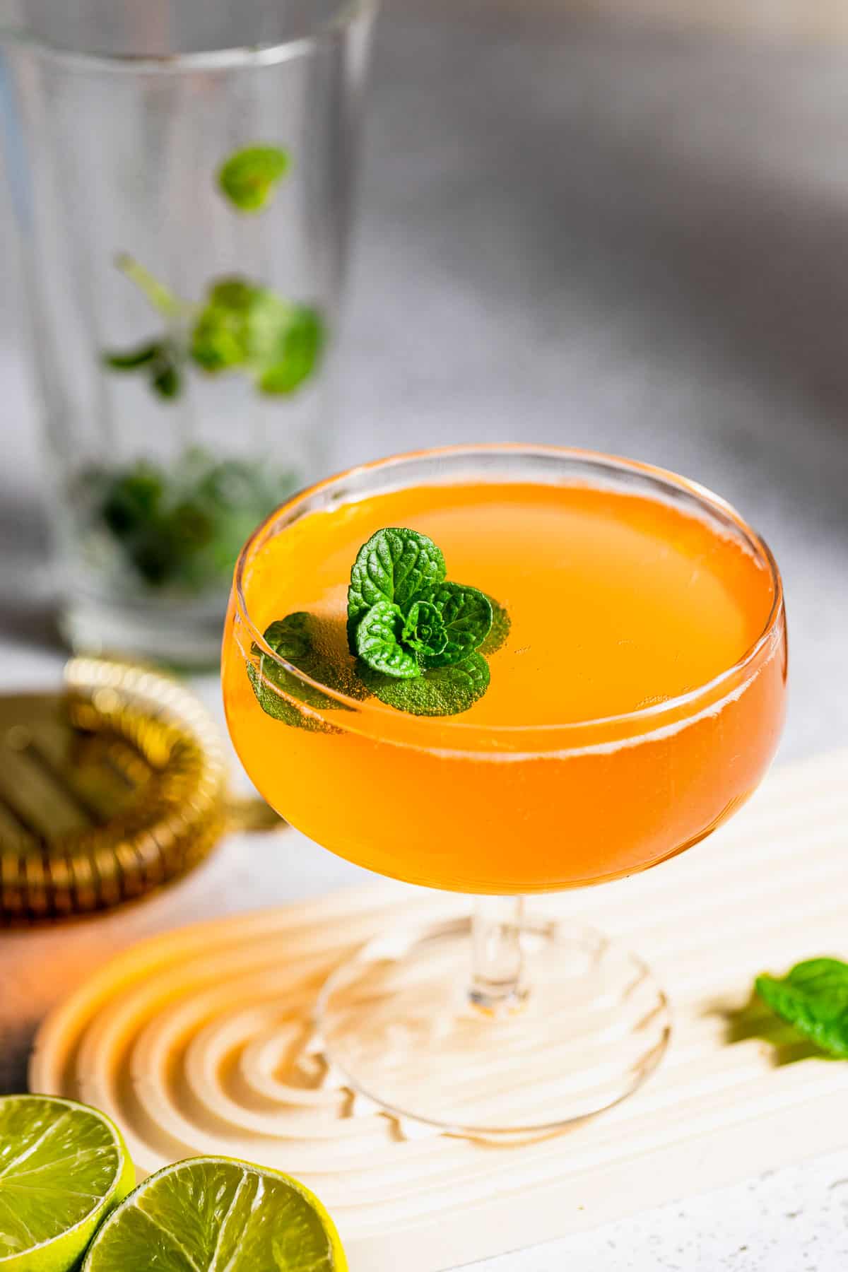 An old Cuban served in a small coupe glass and garnished with a sprig of mint leaves.