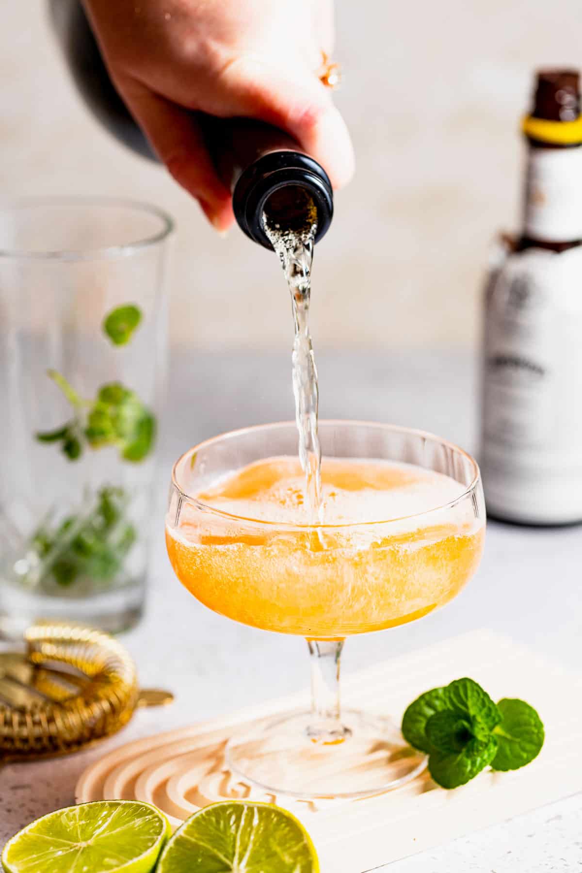 Champagne being poured on top of the old Cuban cocktail.