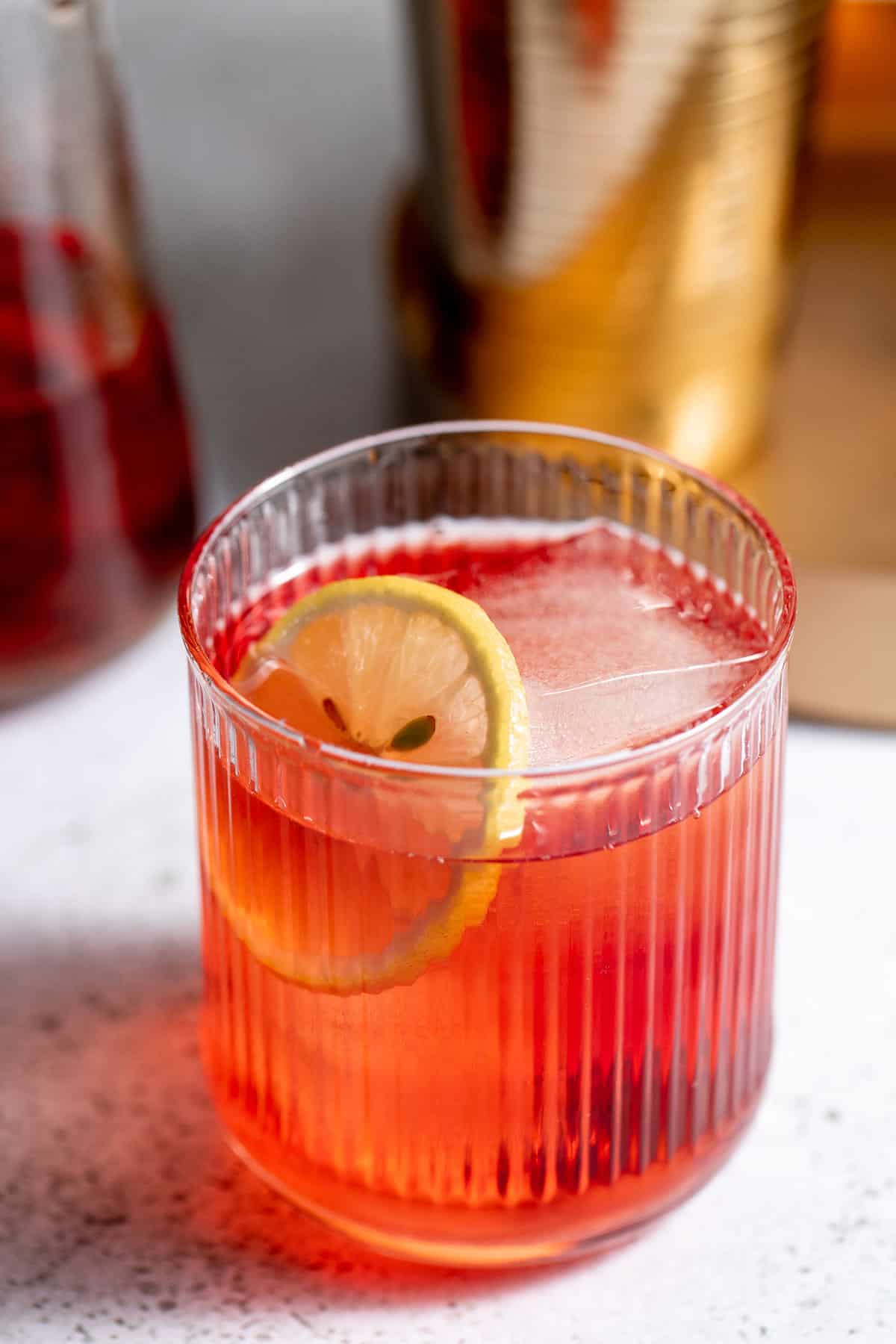 A Royal Flush cocktail served in a rocks glass and garnished with a lemon slice.