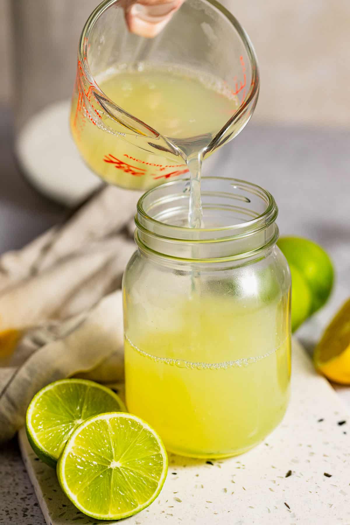 Freshly mixed sweet and sour mix being poured into a mason jar.