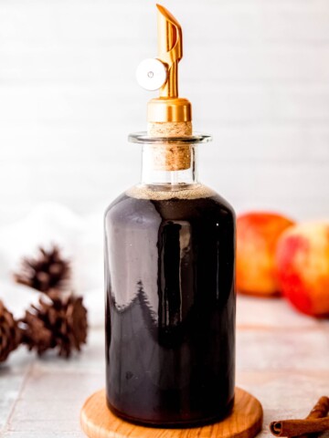 A glass jar filled with apple brown sugar syrup.