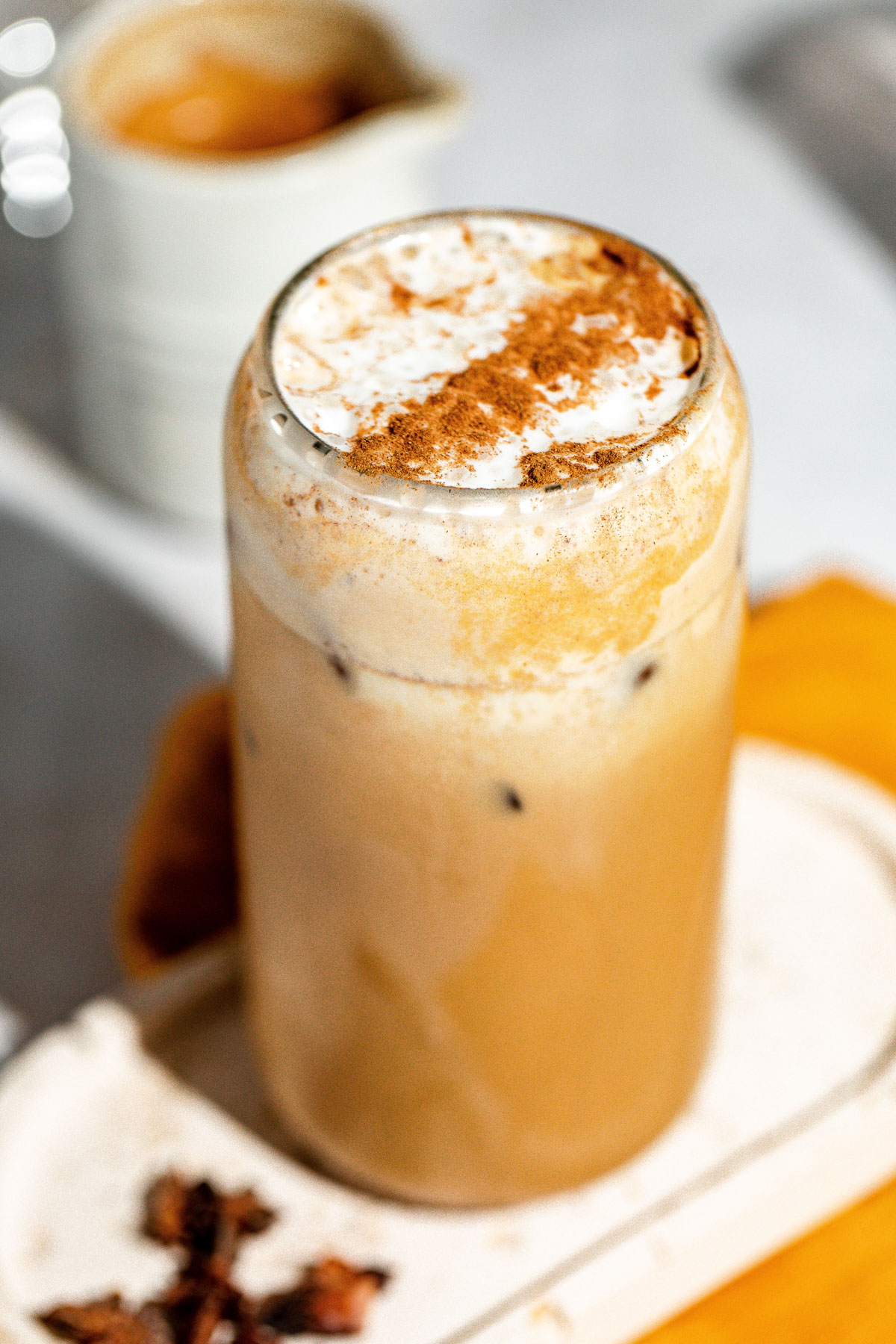 An iced pumpkin spice latte topped with milk foam and ground cinnamon.