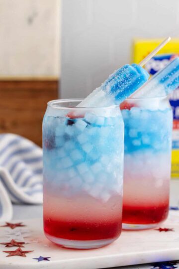 Two red white and blue cocktails served in highball glasses.