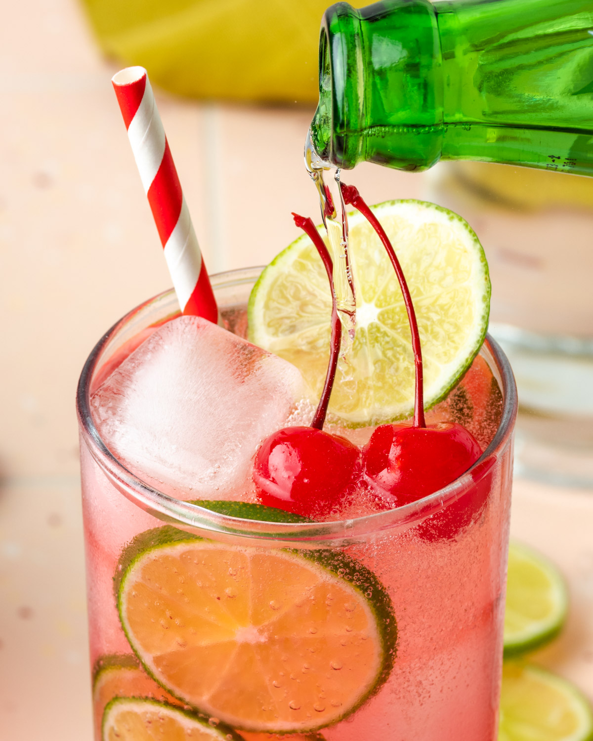 Sprite being poured into a glass of dirty shirley cocktail.
